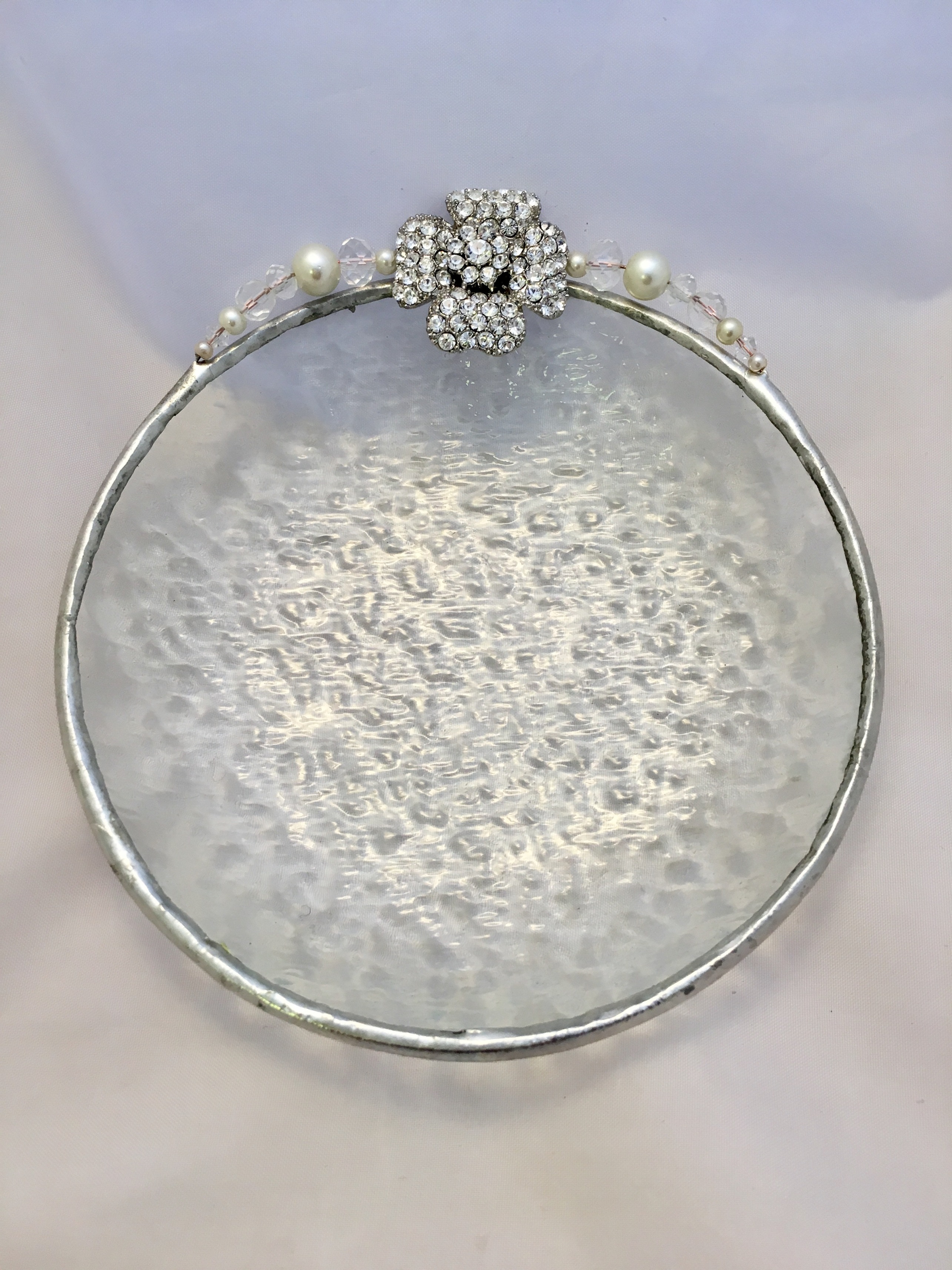 A silver plate with a white background and a decorative design.