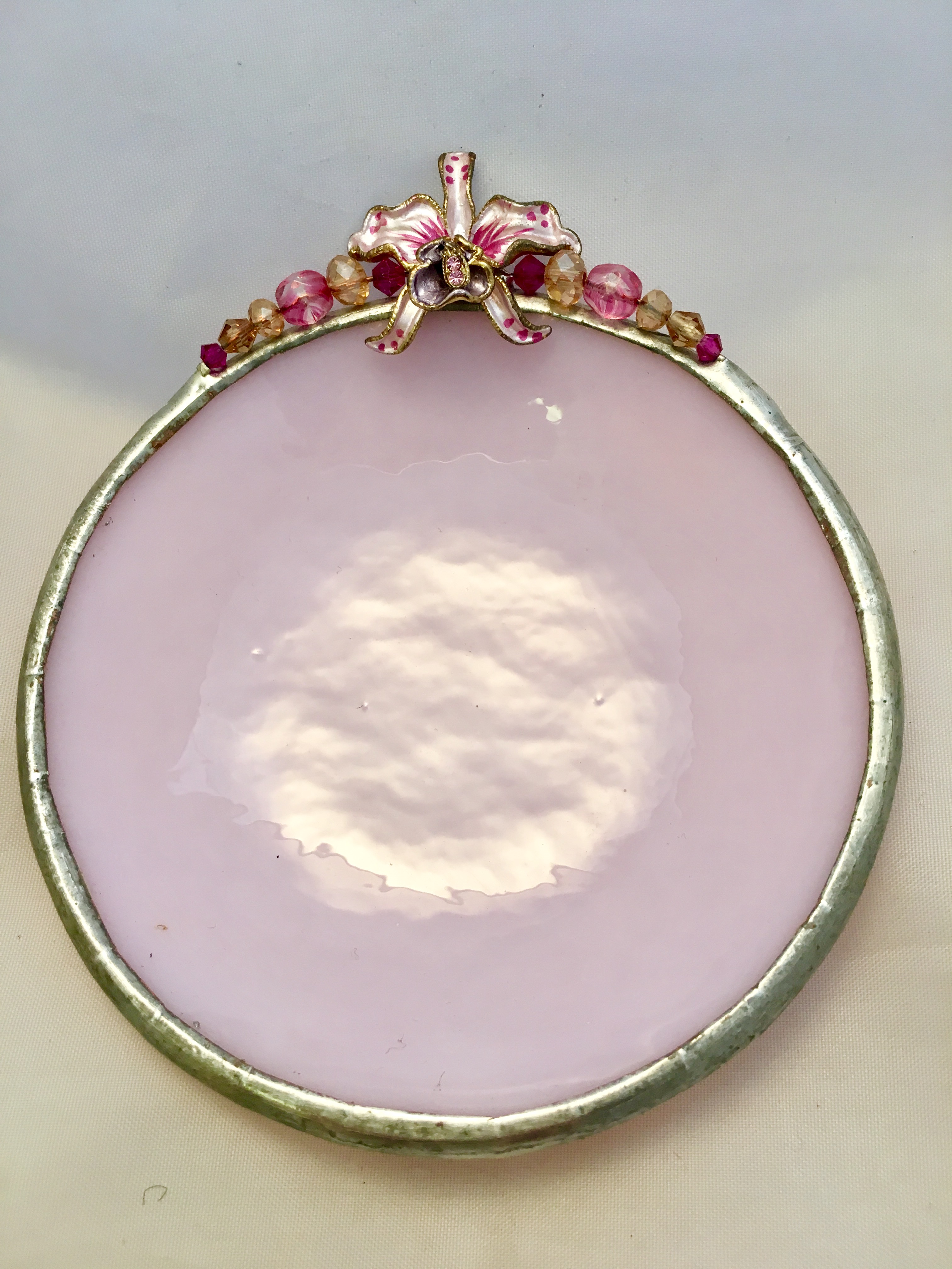 A pink plate with a bow on top of it.