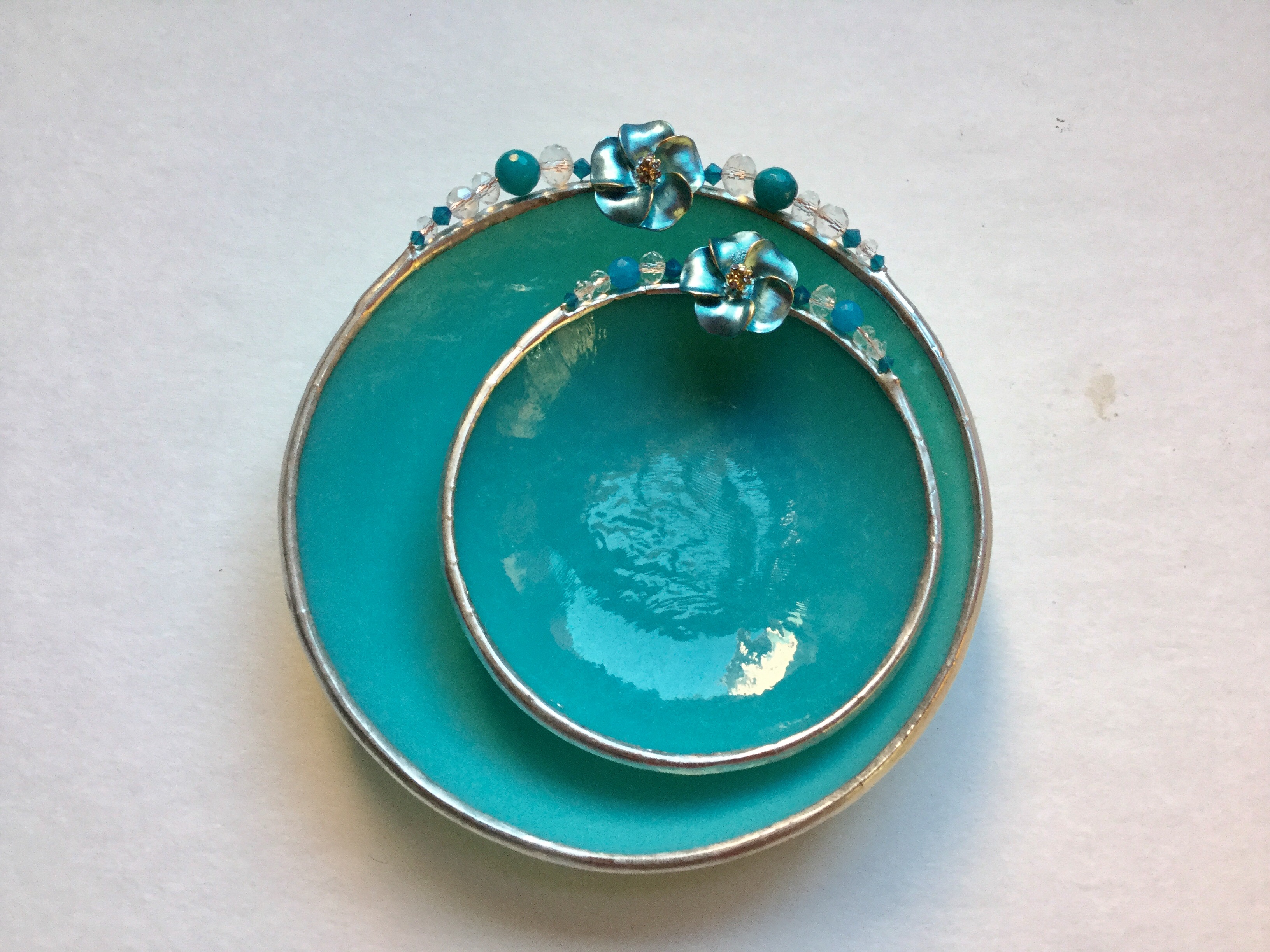 A turquoise bowl and plate with silver rim.