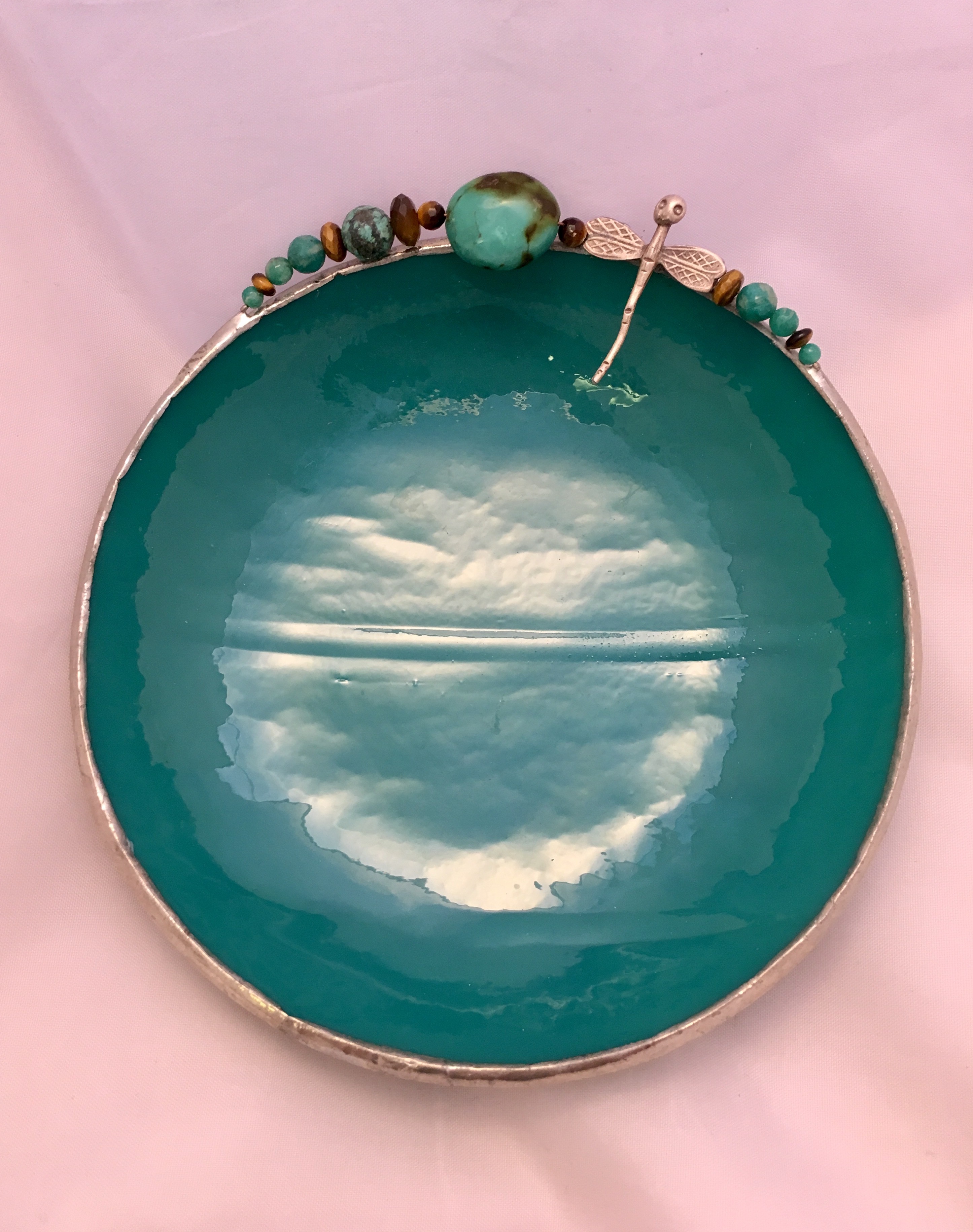 A green plate with some beads on top of it