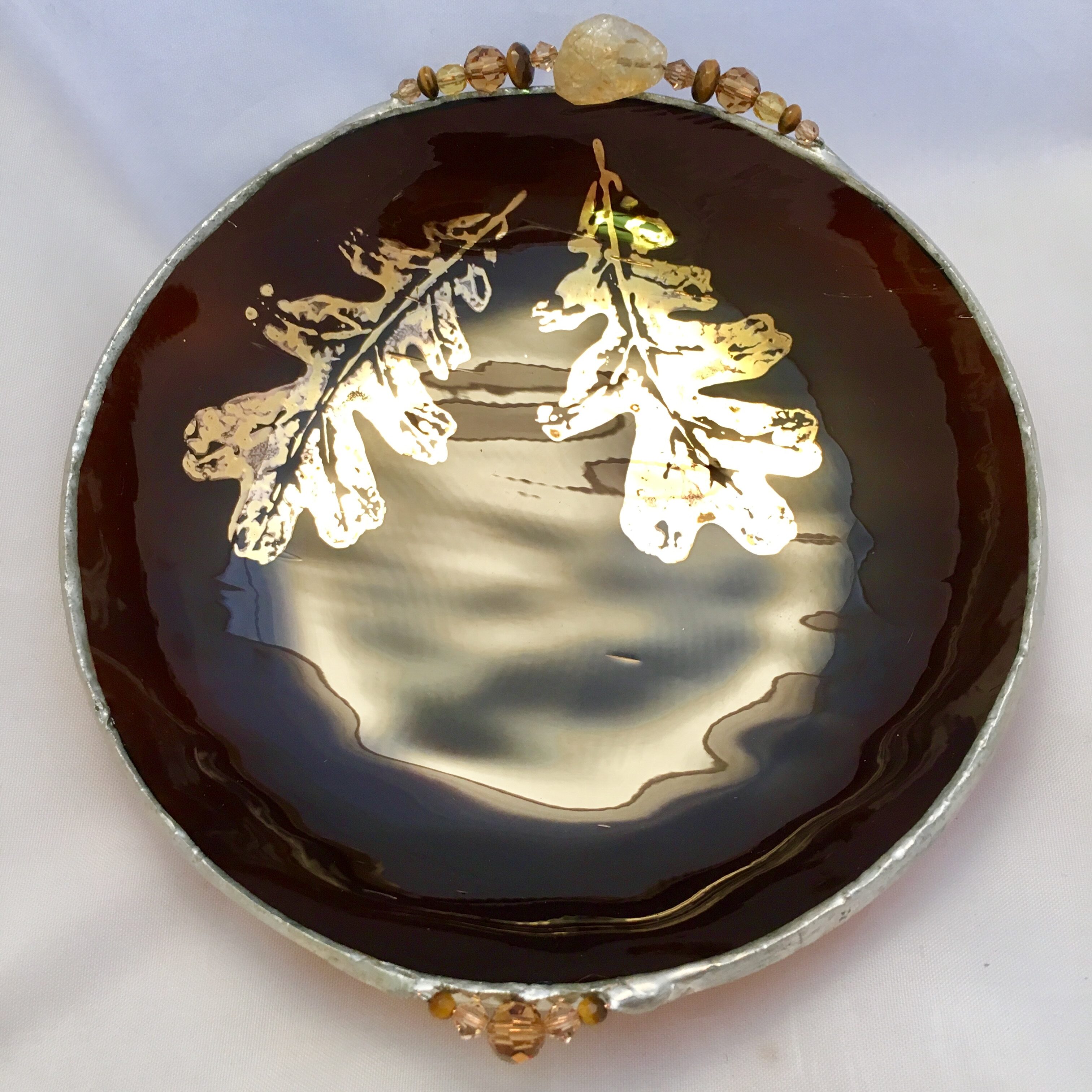 A brown plate with gold leaves on it