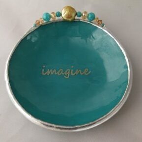 A small plate with the word " imagine " written on it.