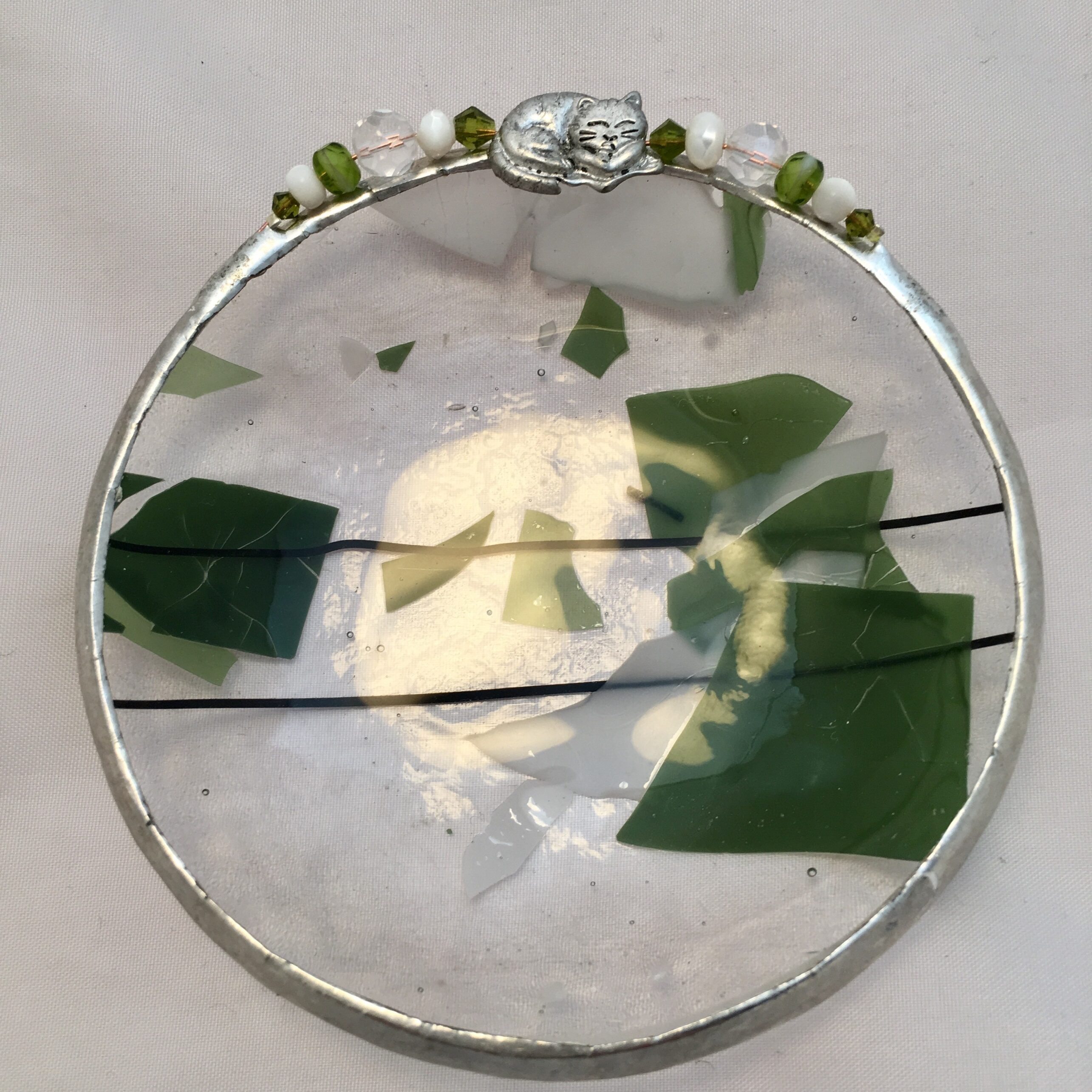 A glass plate with green leaves and white flowers.