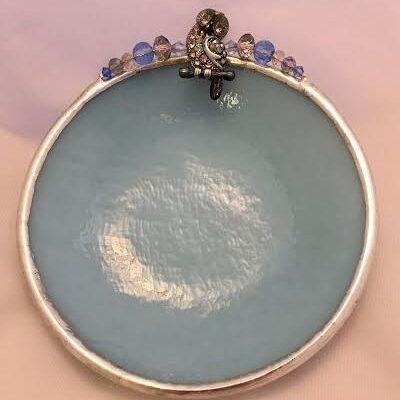 A blue plate with some beads on top of it