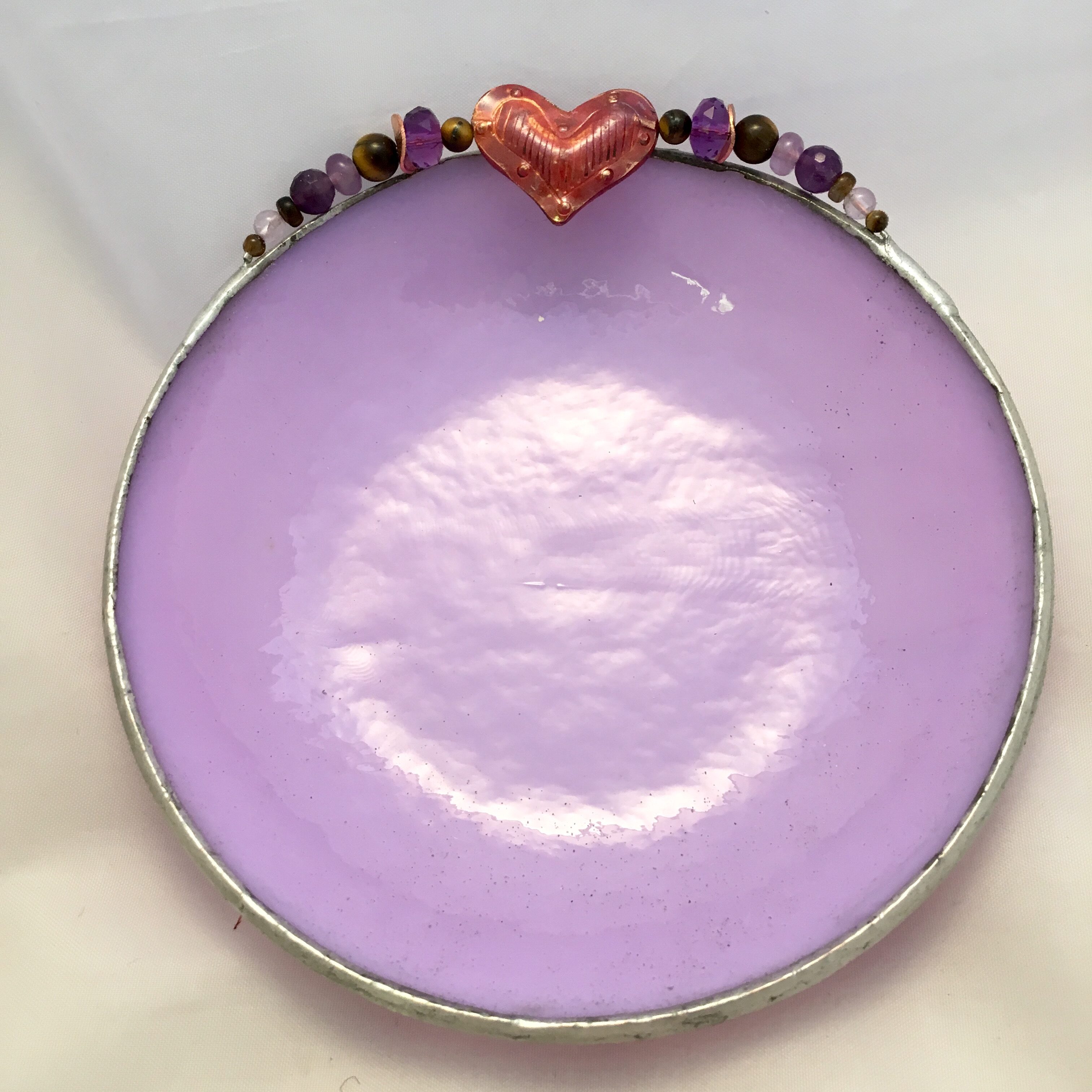 A purple plate with a heart on top of it.