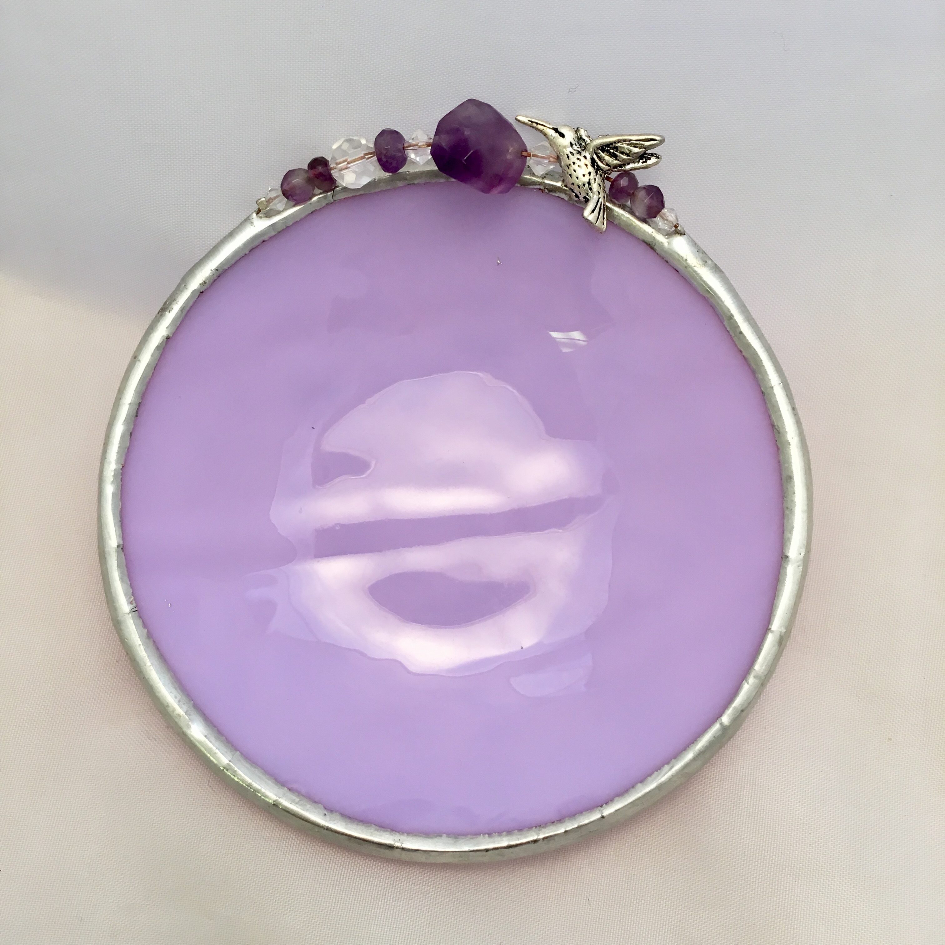 A purple plate with some beads on top of it