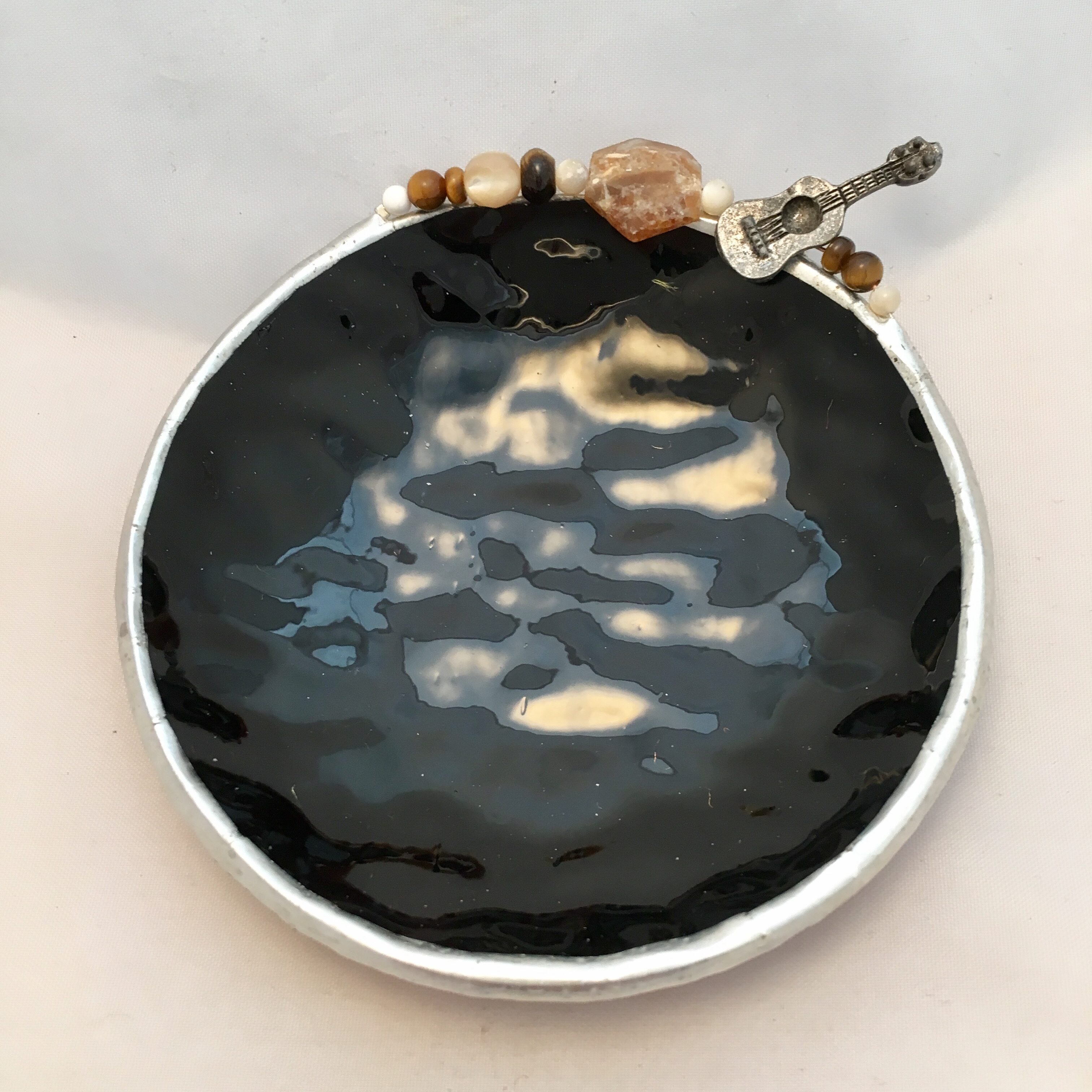 A black and white dish with some beads on it