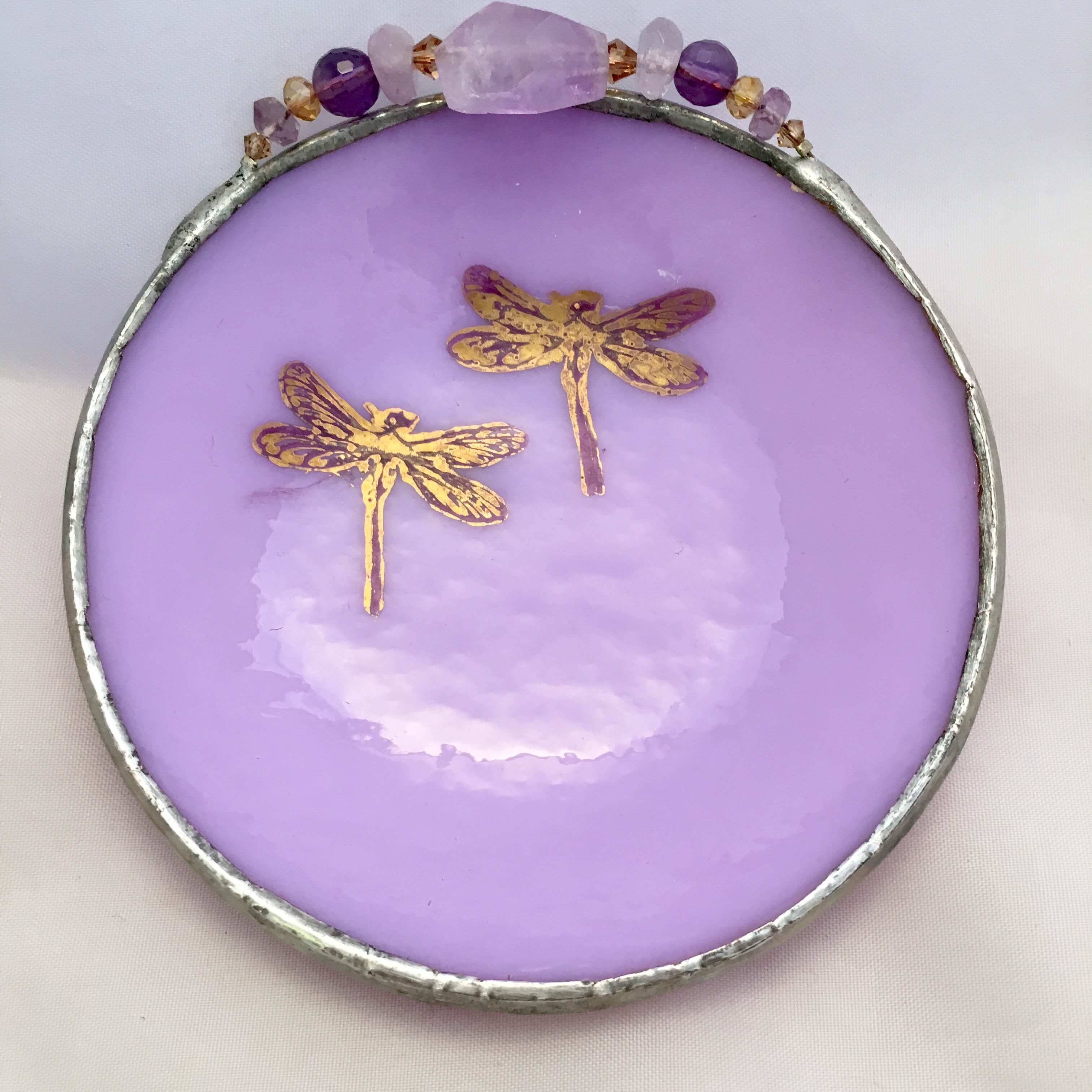 A purple plate with gold dragonflies and amethyst.