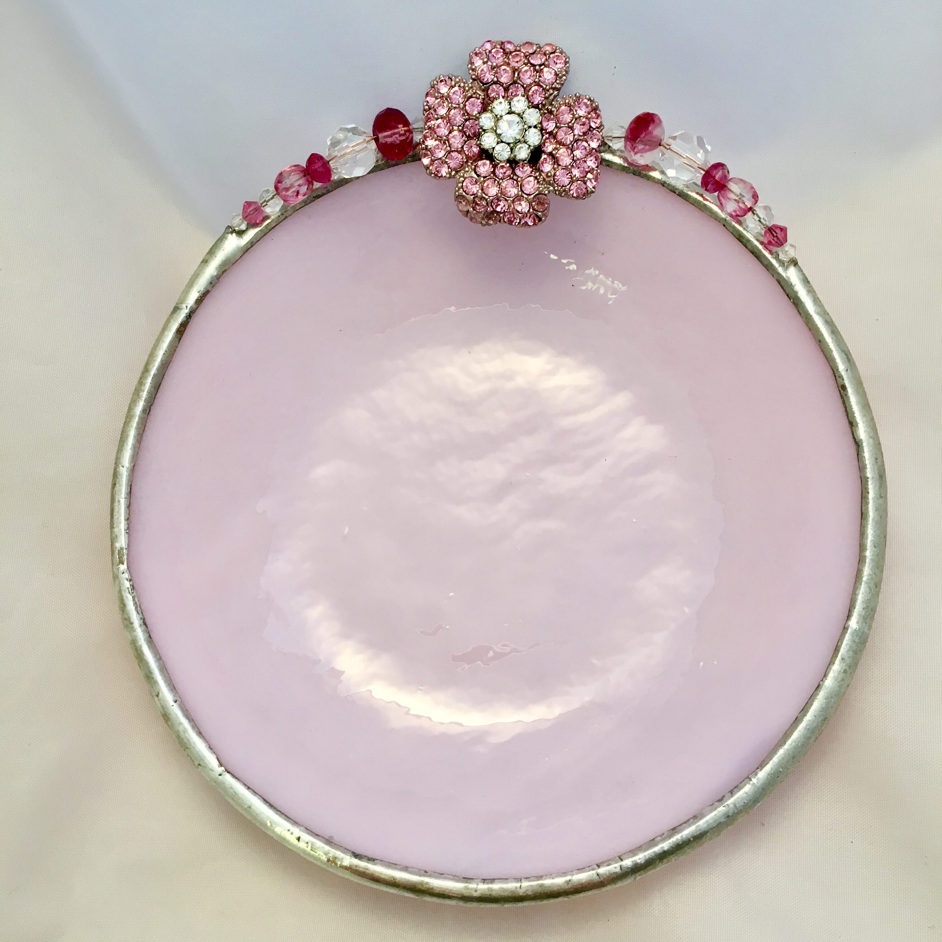 A pink plate with a flower on top of it.