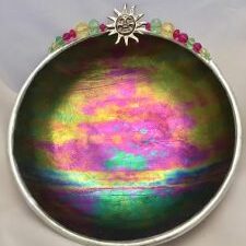 A bowl with a sun on it and some colored glass