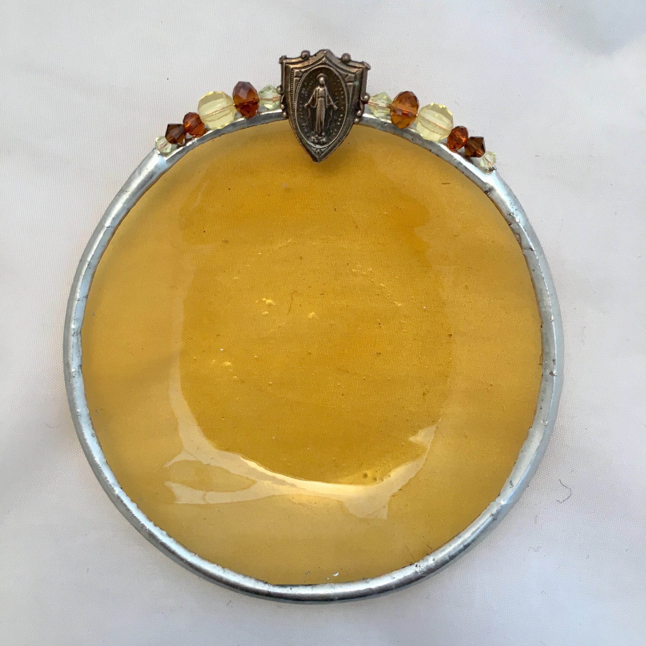 A yellow bowl with some orange beads on top of it