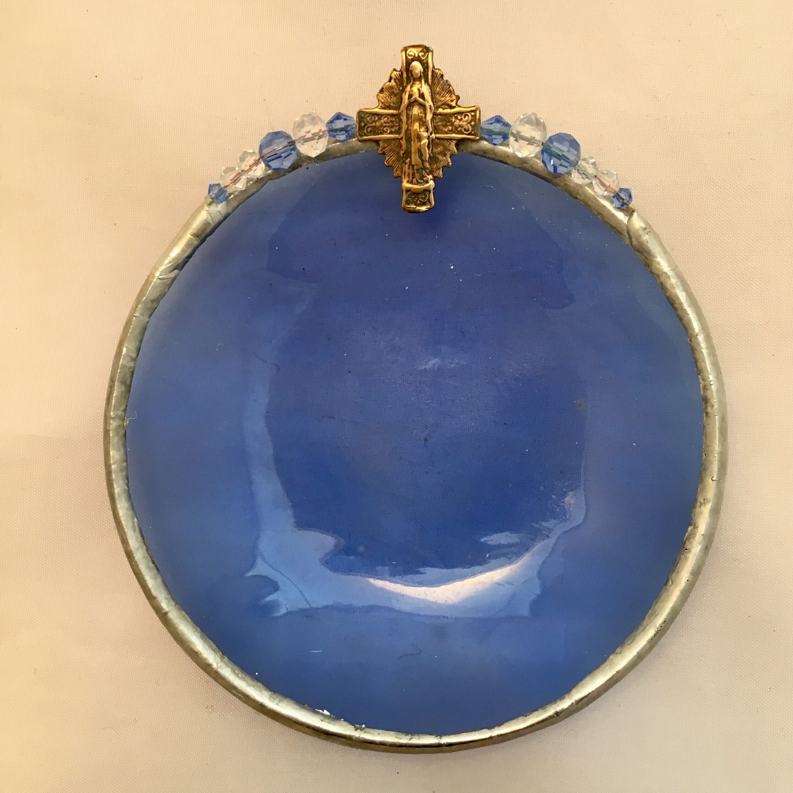 A blue bowl with a cross on top of it.