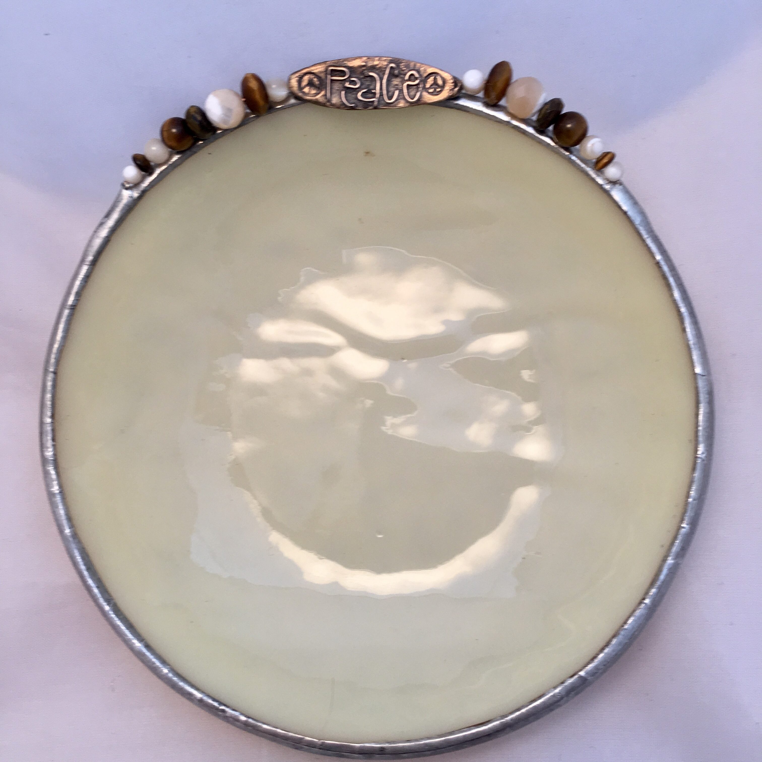 A round white plate with some brown beads on top