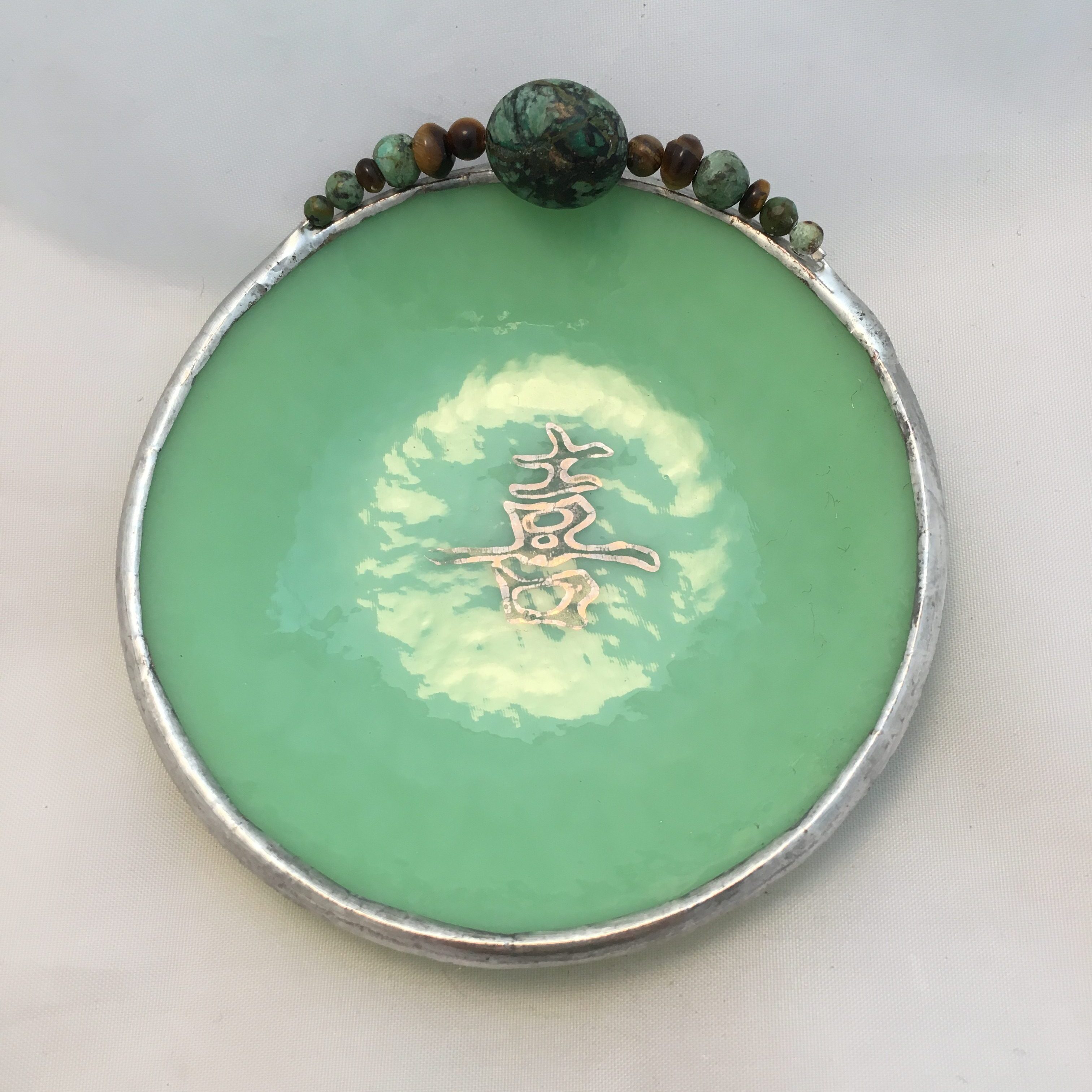 A green bowl with some beads on top of it