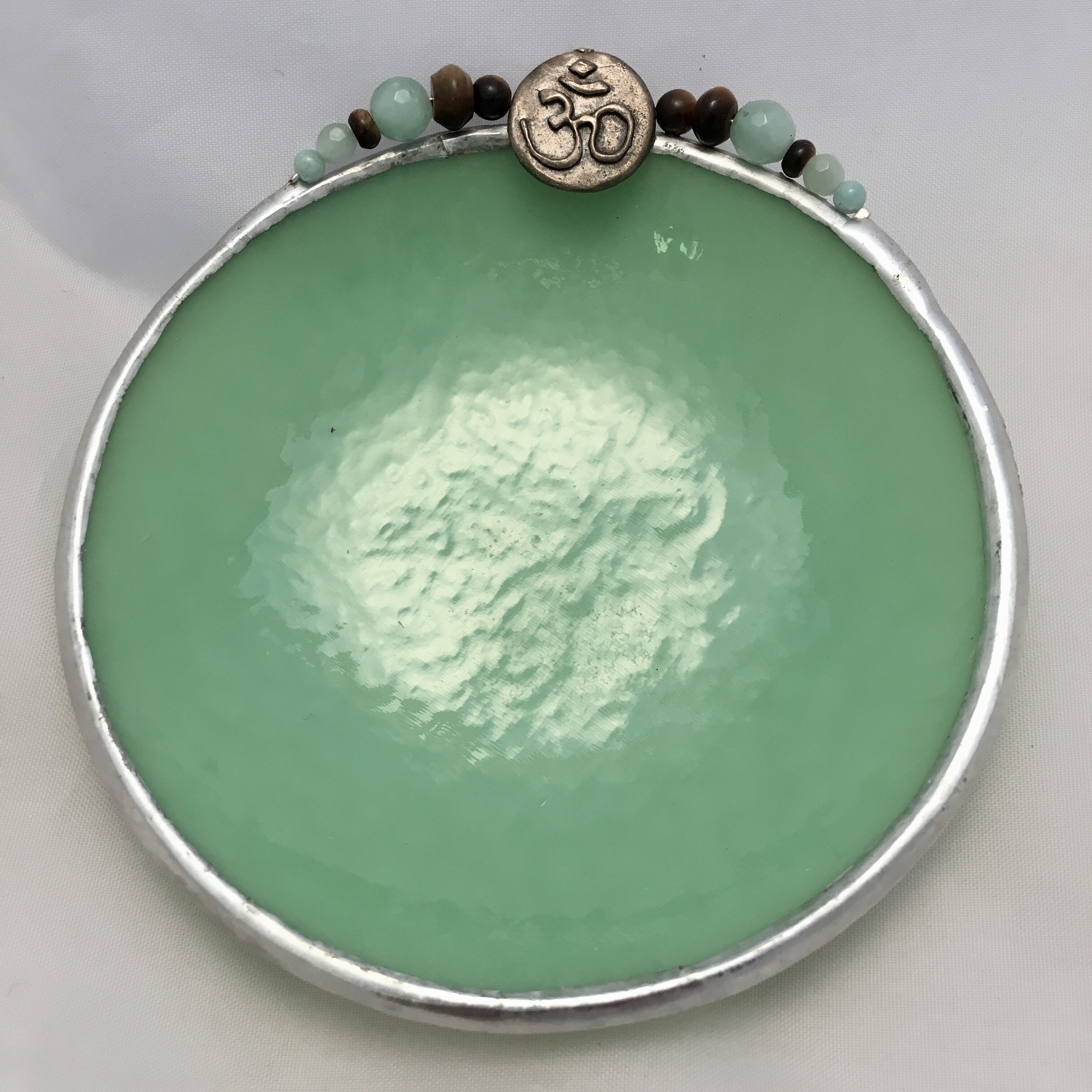 A green bowl with om symbol on top of it.