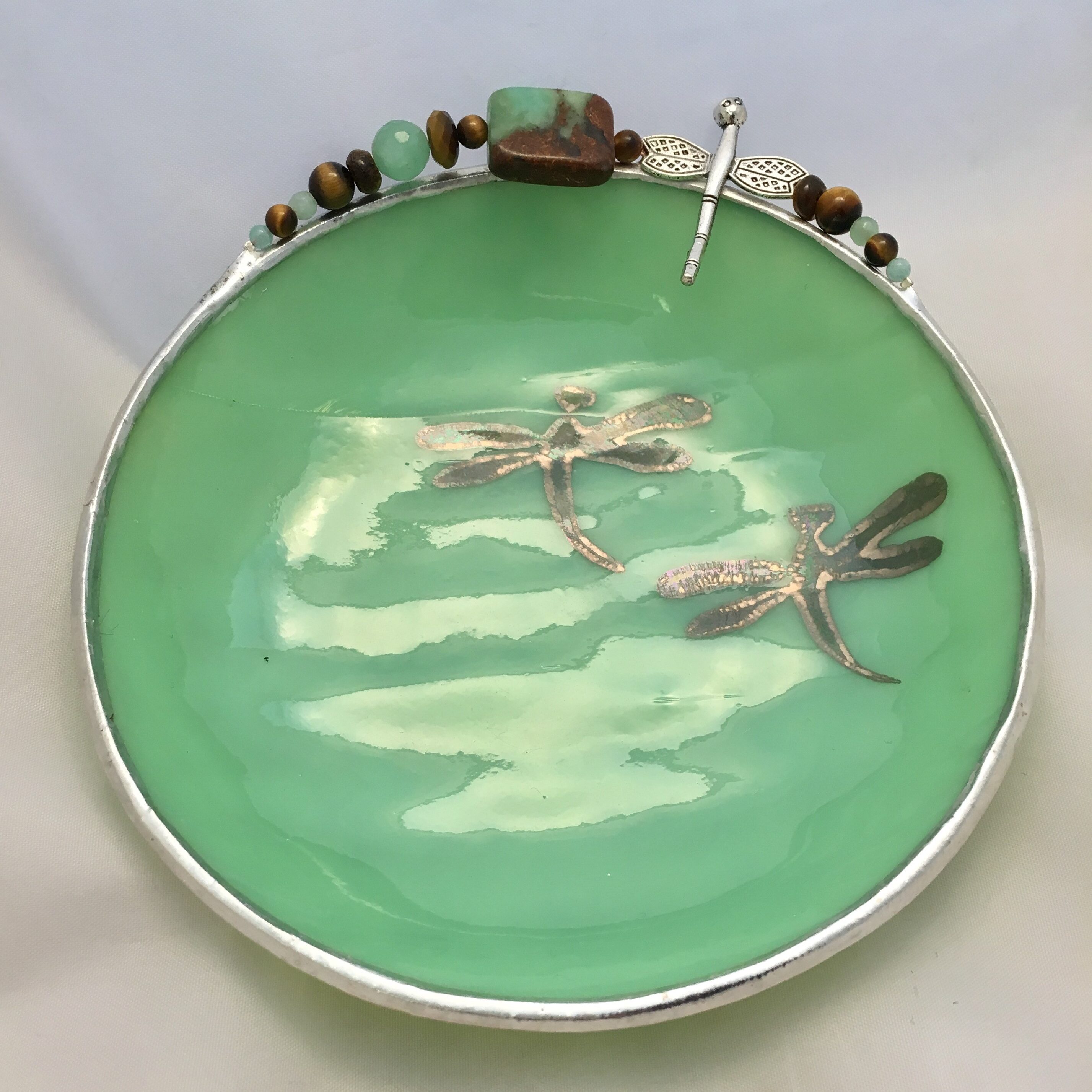 A green plate with two dragonflies on it