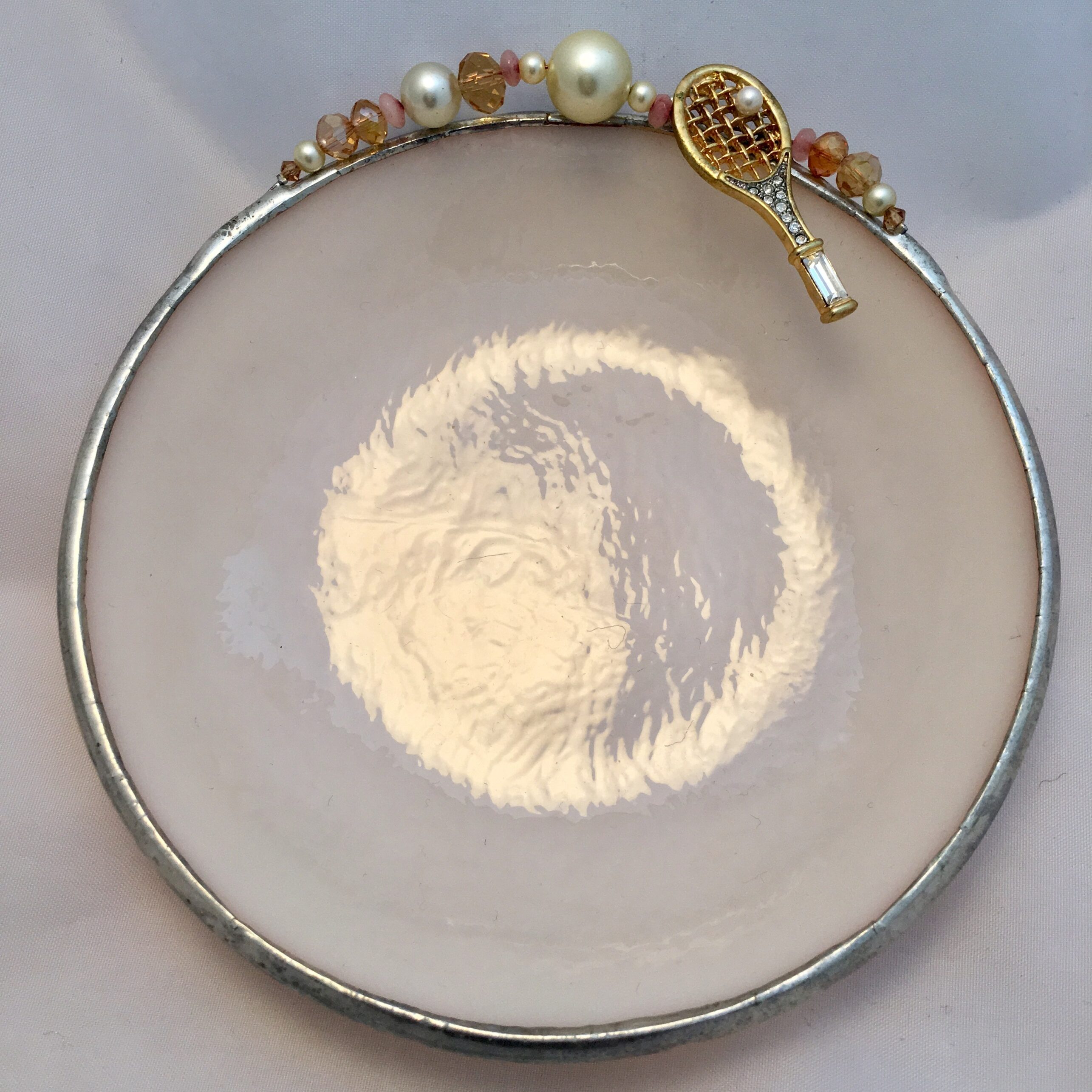 A white plate with some gold and pearls on it