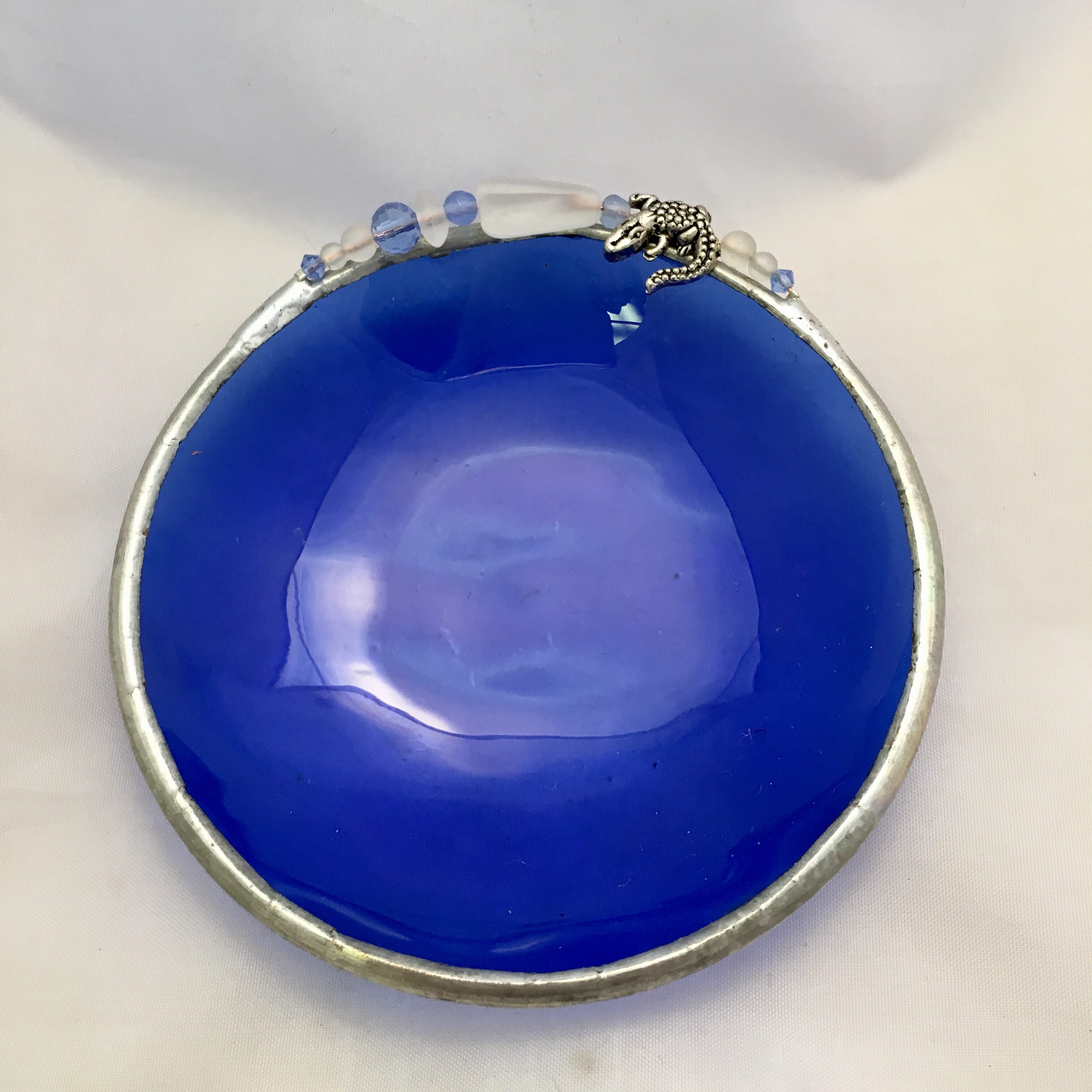 A blue bowl with some kind of charm on top