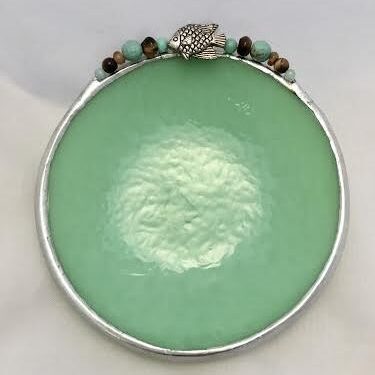 A green plate with beads on top of it.