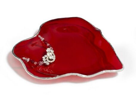 A red dish with silver trim and a diamond shaped design.