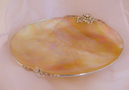 A tray with gold trim and a shell design.